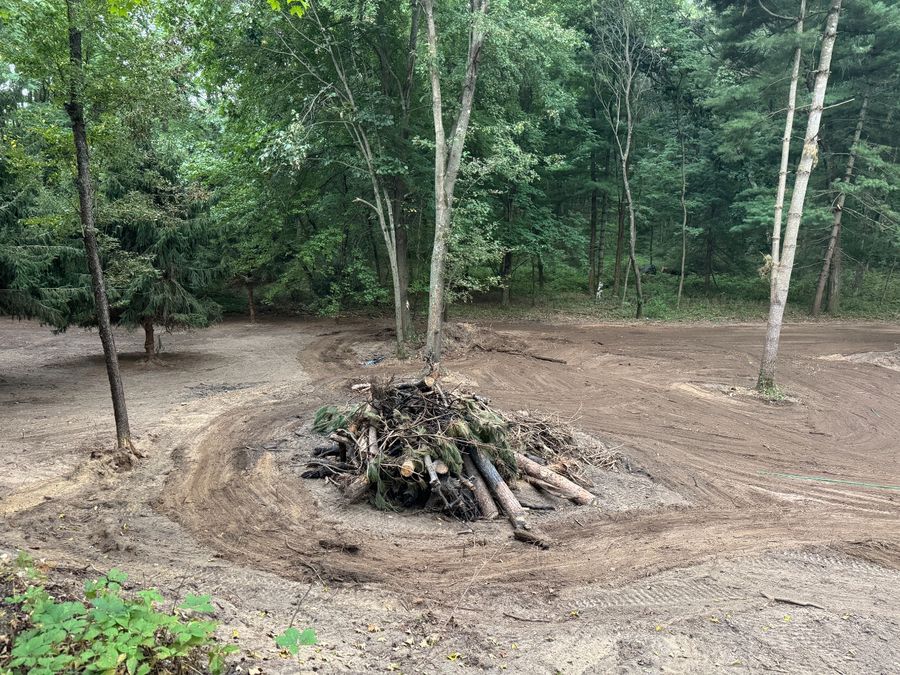 Wooded property cleared and graded with cut timber and brush piled in the center for disposal, Holmen, Wisconsin